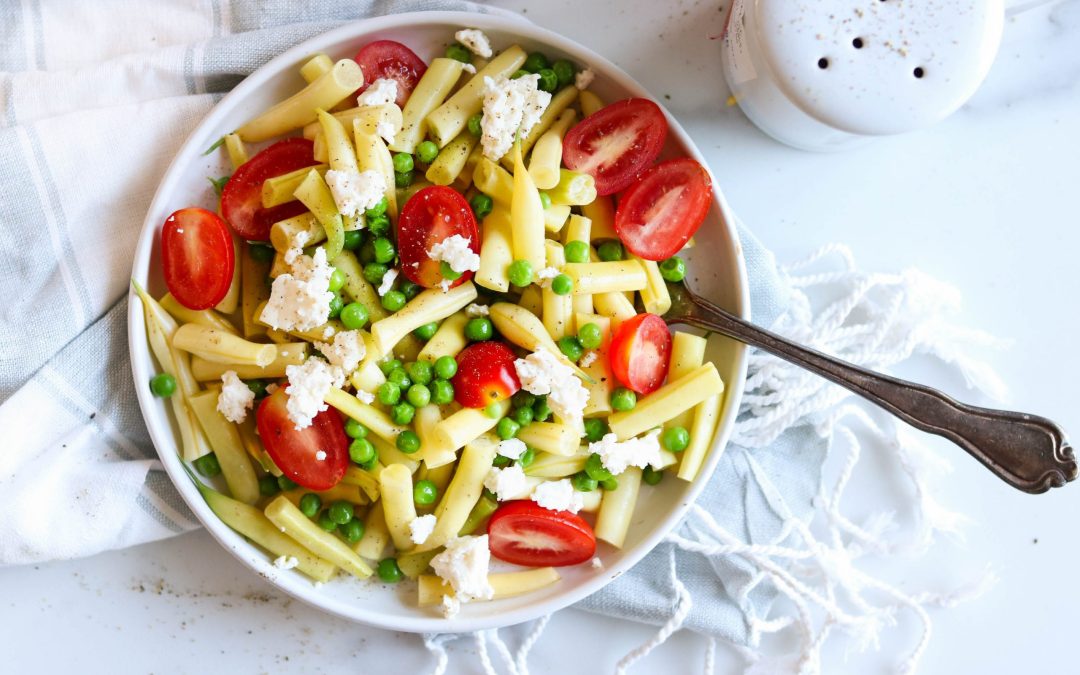 Salade d'haricots jaunes à la méditerannéenne avec tomates cerise, pois verts et feta